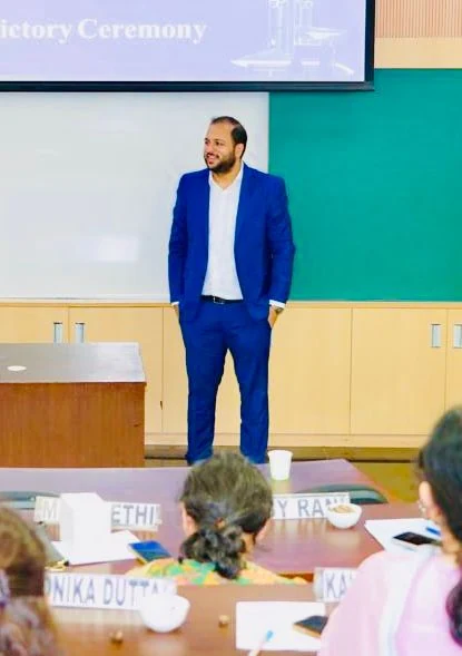 Prof. Sudhanshu Maheshwari speaking to participants seated at a U-shaped table during a programme session