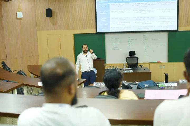 Addressing a seated audience during a Faculty Development Programme session