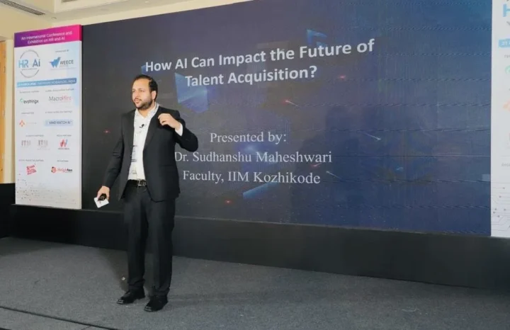 Speaking on stage beside a slide reading How AI Can Impact the Future of Talent Acquisition
