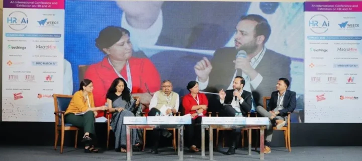 A panel of speakers seated on stage at the summit