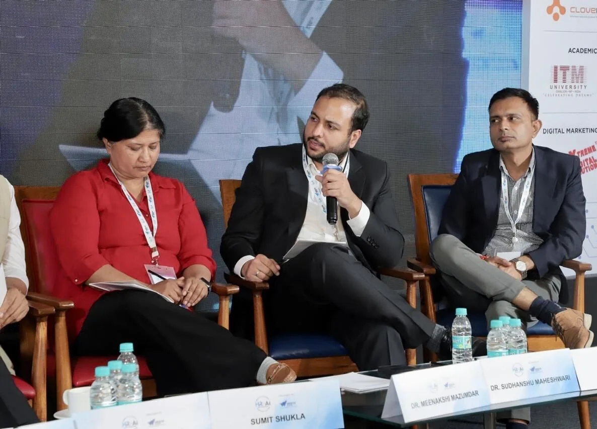 Speaking into a microphone while seated on a conference panel