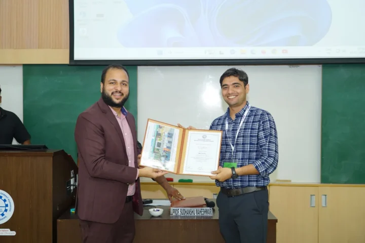 Presenting a framed memento on an auditorium stage