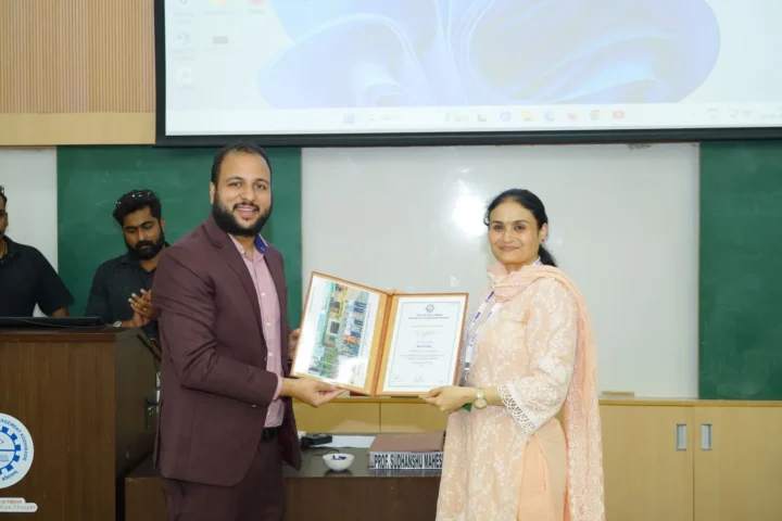 Presenting a framed memento to a participant on an auditorium stage