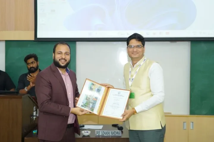 Presenting a framed certificate at the front of a classroom