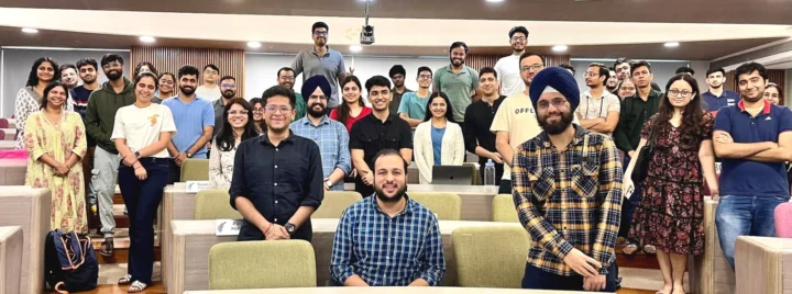 The class standing together at the back of a seminar room