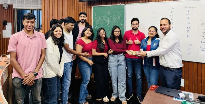A group of students standing together in front of a blackboard