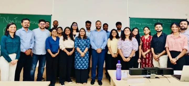 A cohort of HR professionals standing together in front of a blackboard