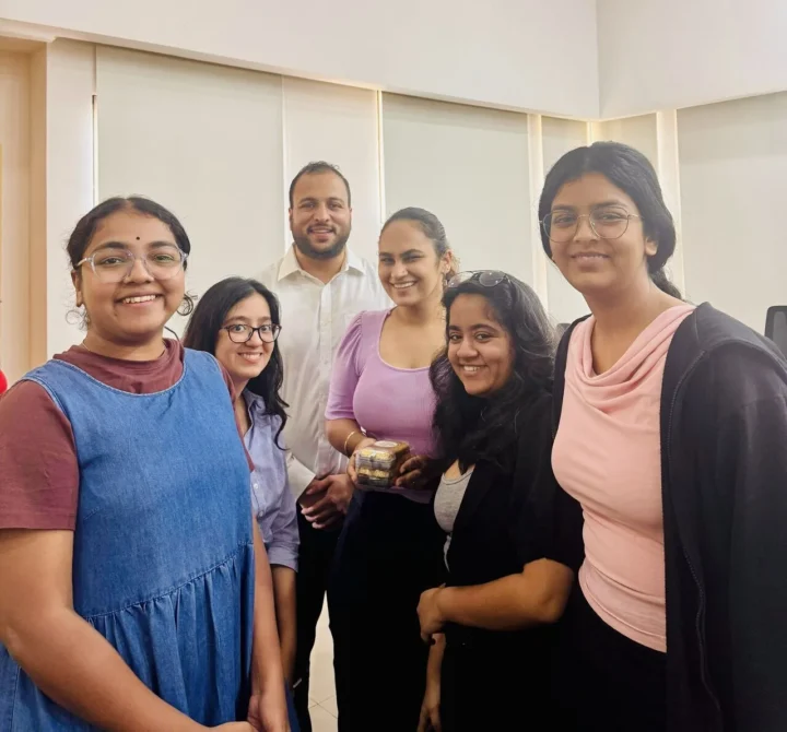 Five participants standing together in a classroom