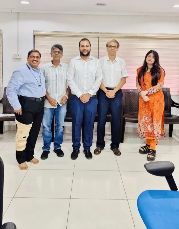 Five colleagues standing together in an office