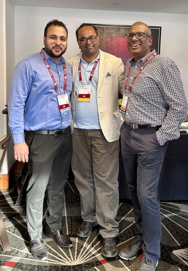Three conference delegates standing together in a hotel lobby