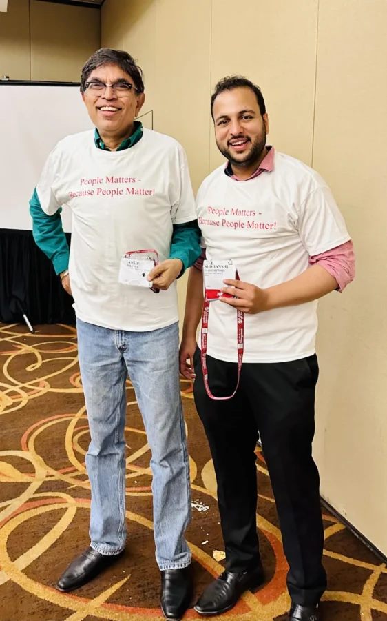 Two delegates holding up printed T-shirts at the conference