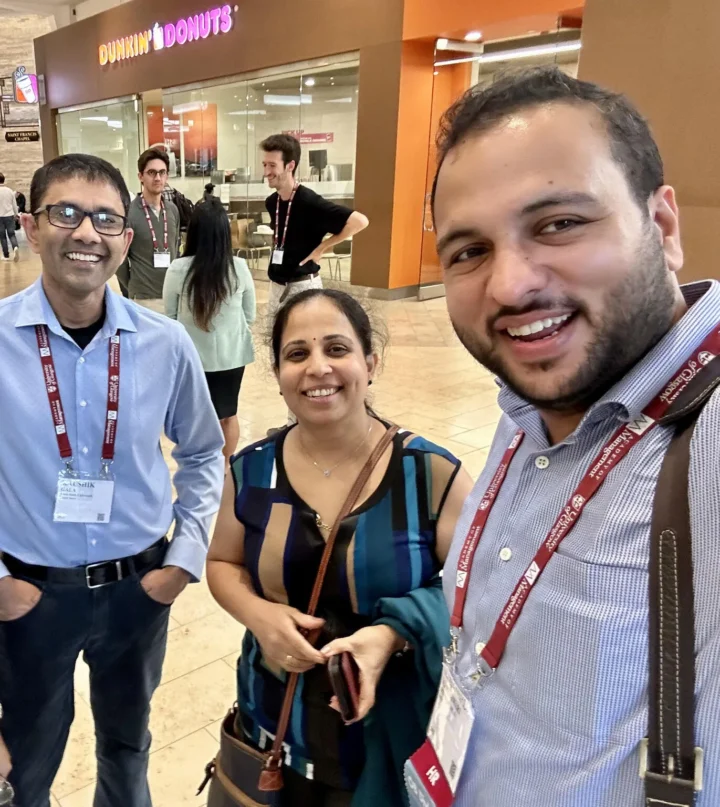Three colleagues photographed in a convention centre concourse during a break