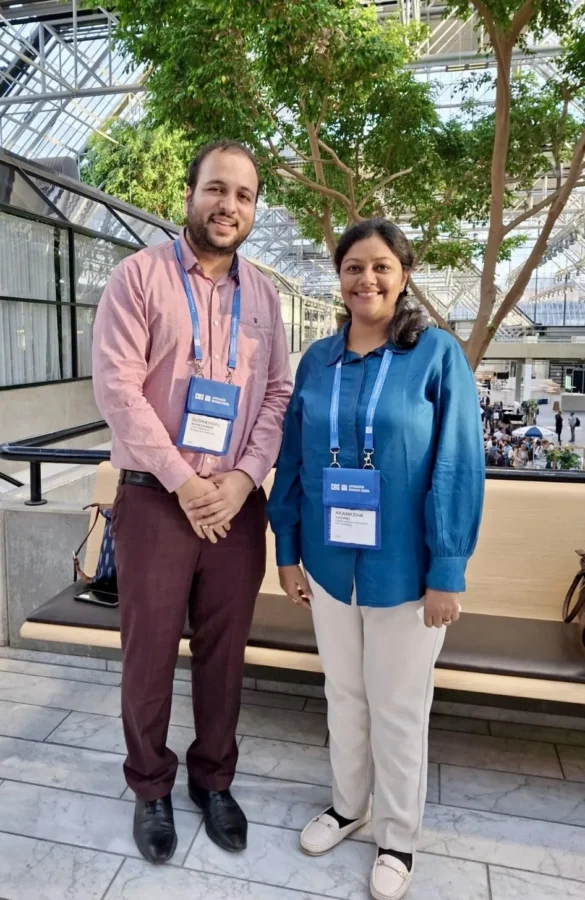 Two delegates standing outdoors on a campus