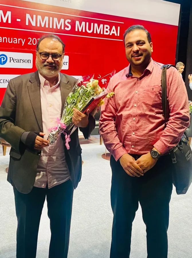 Holding a bouquet beside a colleague in front of the INDAM 2023 backdrop