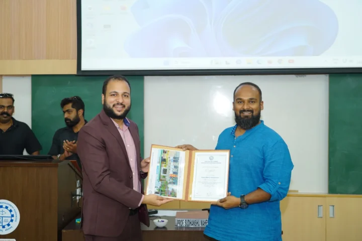 Presenting a framed certificate at the front of an auditorium