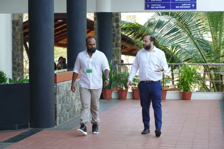 Two people walking through a campus corridor