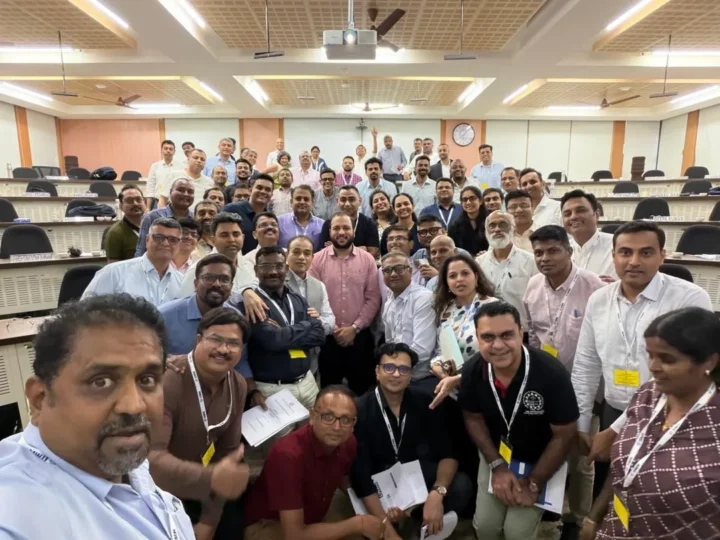 A large cohort of senior executives photographed together in a classroom