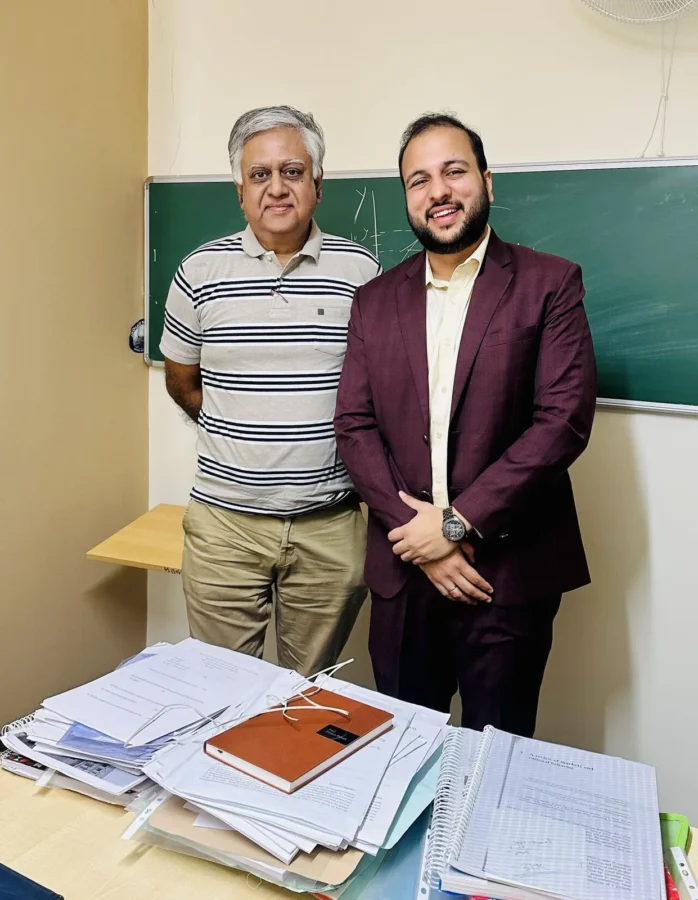 Two people standing together in front of a blackboard